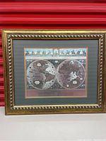 Framed Blaeu wall map showing two hemispheres mounted on a green mat with a gold frame.