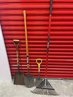 Full view of four gardening tools including Ridgid shovel, Ridgid spade, mini spade, and Troy-Bilt rake against red background.