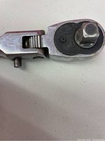 Close-up of the ratchet socket wrench head showing the square fitting and adjustment mechanism