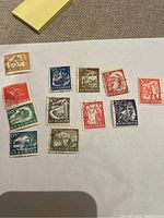 Full set of 12 vintage Romanian stamps on white paper showing various themes and colors.