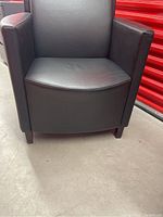 Front view of black leather armchair showing seat and arms