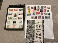 Canada Centennial issue album with stamps from 1867-1967, 1966 price list for US stamps, and loose stamps on white paper.