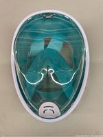 Top full view of the teal and white kids underwater mask showing the curved face shield and front ventilation valve.