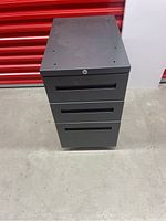 Front view of closed Technion metal filing drawer cabinet in dark grey color.
