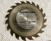 Carbide-tipped saw blade with 20 teeth, labeled for cutting various materials including wood and plastic.