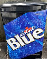 Front view of the bar fridge showing the Labatt Blue branded door panel with a blue ice pattern and maple leaf logo.
