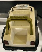 Photo of Paw Patrol themed toy vehicle showing rear, white and black plastic with green roll bar and tail lights.