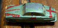 Top view showing the green diecast car with red painted cross and stripes.