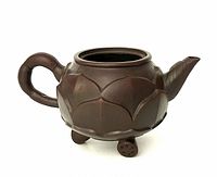 Yixin clay lotus teapot side view showing handle and spout.