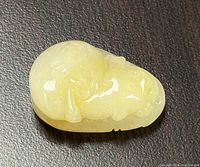 Front view of the yellow jadeite carved pendant showing intricate details of the carving.