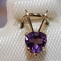 Close-up photo showing the 14K yellow gold pendant with a pear-shaped amethyst gemstone in a 3-prong setting.