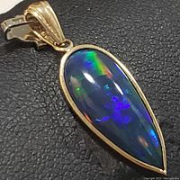 Close-up of opal pendant showing color play and gold bail