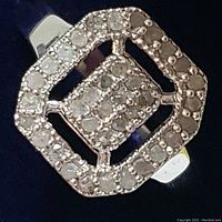 Close-up of the ring face showing diamond clusters in a double square halo pattern set in sterling silver rhodium plated band