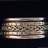 Close-up of the sterling silver ring showing the braided design and polished bands with notch details.