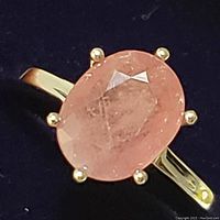 Close-up front view of oval faceted ruby on sterling silver band, showing stone color and clarity