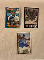 Front of three Ken Griffey Jr baseball cards including 1989 Topps Mariners card and "The Griffeys" black and white card