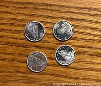 Obverse side of four 1960s Canadian silver dimes showing the Bluenose schooner and the year minted (1961, 1962, 1963, 1966).