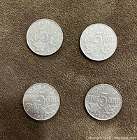 Reverse side of four Canadian nickels showing the 5 cents denomination and the years: 1930, 1931, 1932, 1934