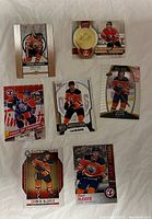 Seven Connor McDavid hockey cards laid out face up, showing different poses and styles, including limited edition and brand logos.