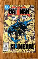 Front cover of Batman comic book issue #364 October, shows Batman with many faces in background.