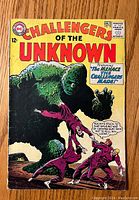 Front cover of the vintage DC comic book 'Challengers of the Unknown' issue #38, showing a large green monster grabbing one of three men in uniform.