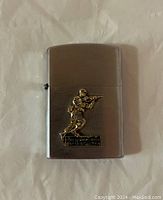 Front view of metal lighter with soldier figure and Fort Leonard Wood Missouri plaque