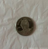 Front side of coin showing engraved portrait of Wayne Gretzky with name around edge.