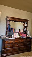 Front and angled views of the vintage wooden dresser with mirror and multiple drawers, showing carved details and shelving.