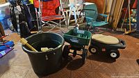 Scott's seed spreader, garden stool, laundry bin, and furniture movers arranged on floor.