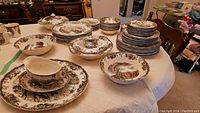 Overall view of stacked plates, bowls and covered serving bowls on table