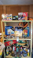 Shelving full of all items including boxes of Velcro, Garmin GPS, Tow Truck in a Box, steel wool pads, assorted hardware and cans on lower shelves.