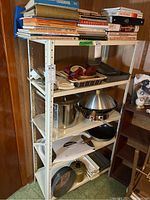 Full view of metal 5-shelf utility storage shelf with various kitchen items on shelves. Shelf appears sturdy and fully assembled.