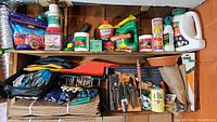 Shelf with various garden chemicals, gloves, tools, lawn bags, burlap, growing tray, and gardening shears (Fiskars)
