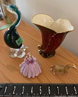 Photo showing all four items: ceramic vase, glass bird, Coalport figurine, and ceramic pony, with measurement scale.