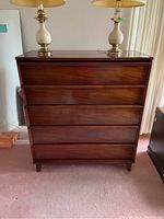 Front view of dresser showing five drawers and dark wood finish