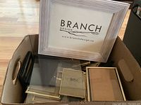 Box containing a large wooden frame with Branch Design branding and multiple smaller assorted frames inside