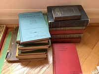 A pile of vintage school and reference books including Ontario Public School Health Book with blue-gray cover and Dominion High School Chemistry with red cover, stacked on hardwood floor.