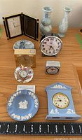 Full view of the collection showing Wedgwood ashtray and clock, five other clocks, two vases, and collectors plate.