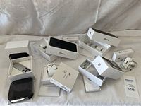 Full display of Apple product boxes, AirPods, cables and adapters on white cloth background.