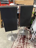 Pair of Beovox M70 speakers on stands in garage setting