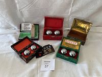 All four pairs of Chinese exercise balls in decorative boxes arranged on a white cloth background showing variations in box colors and styles.