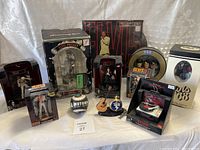 Overview photo showing the collection of Elvis Presley collectibles including multiple figurines, musical ornaments, Pez dispenser, mini guitar, and memorabilia items in packaging.