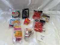 Photo of 8 sealed McDonald's Happy Meal and Adventure Meal toys arranged on a white surface.