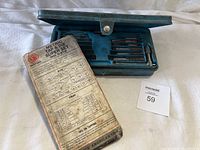 Blue plastic case containing metric taps and dies set with tools, partially opened showing contents.