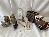Full lot showing all items including two bookends, three temperature gauges, a toy truck, and a black cast hand.