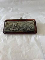 Full view of the vintage coin purse showing cherub metal decoration on front