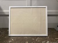 Front view of corkboard showing white frame and light cork surface
