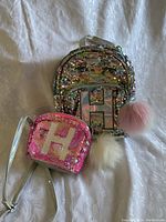 Mini backpack and handbag both with initial 'H' sequined and with attached fluffy pompoms.