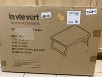 Photo of the box packaging showing brand 'la vie vert', product label and sketch of puzzle tray with folding legs.