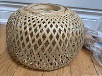 Close-up of the woven rattan shade showing the basket-weave pattern and dome shape.